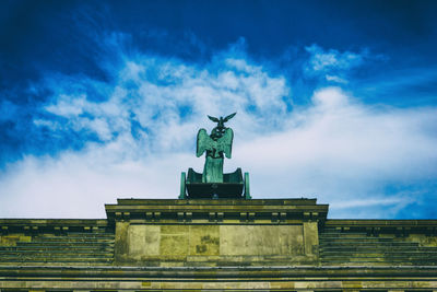 Low angle view of brandenburg gate against cloudy sky