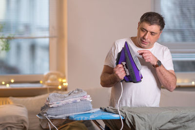 Man holding iron at home