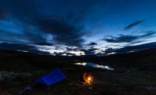 Blue tent and bonfire outdoors in sweden