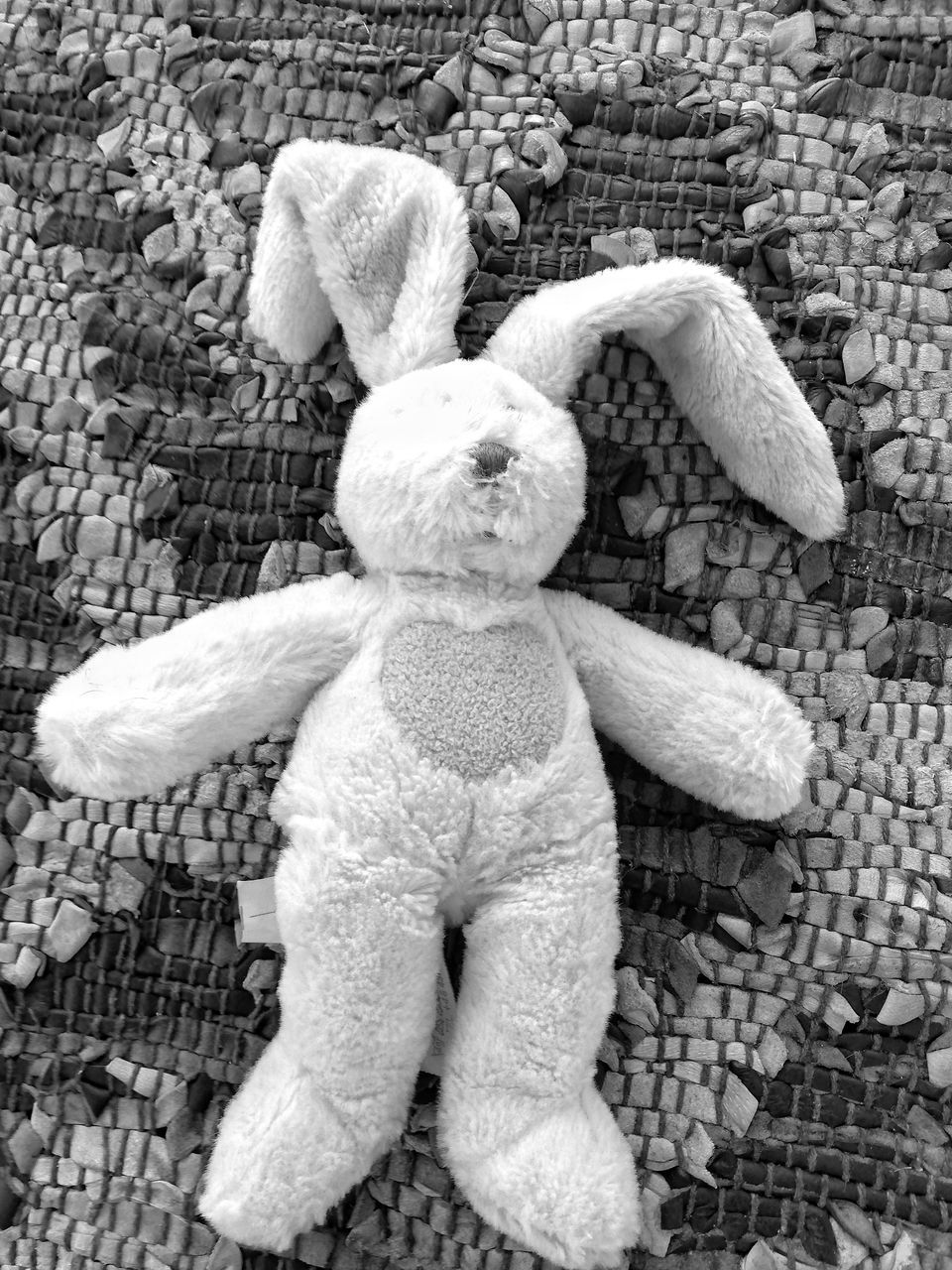 HIGH ANGLE VIEW OF STUFFED TOY ON COBBLESTONE