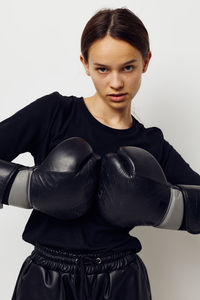 Portrait of young woman standing against white background