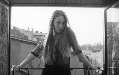 Portrait of woman standing against sky in balcony