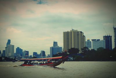 Sea by cityscape against sky