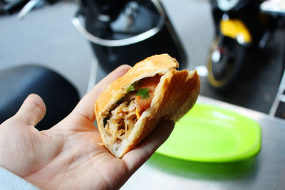 Close-up of hand holding bread in plate