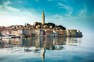 Buildings by sea against sky in city