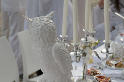 Close-up of white owl statue at dining table