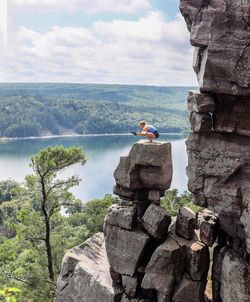 People on cliff by sea against sky