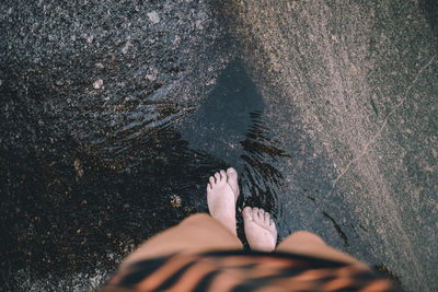 Low section of woman standing on sand