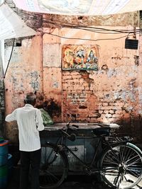 Rear view of woman standing against wall