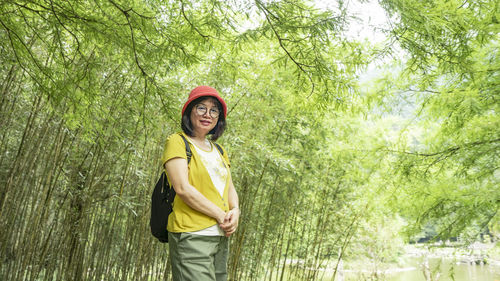 Portrait of woman standing in forest