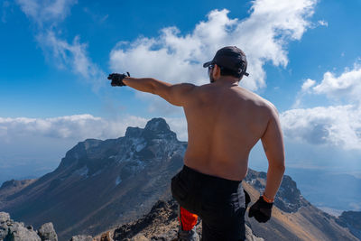 Rear view of shirtless man looking at mountain