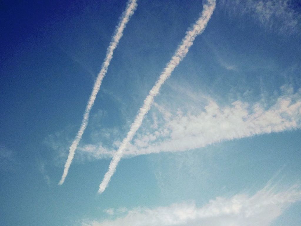 blue, low angle view, sky, vapor trail, beauty in nature, nature, sky only, cloud - sky, tranquility, scenics, day, outdoors, tranquil scene, no people, cloud, white color, flying, idyllic, backgrounds, sunlight