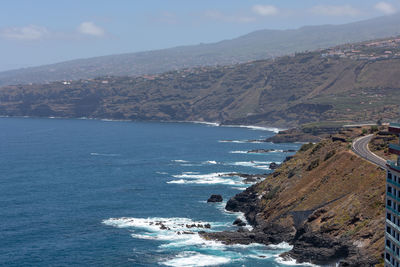 Scenic view of sea and mountains against sky