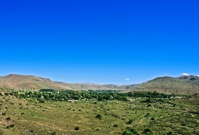 Scenic view of field against clear blue sky