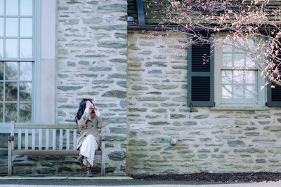 Rear view of woman standing by window