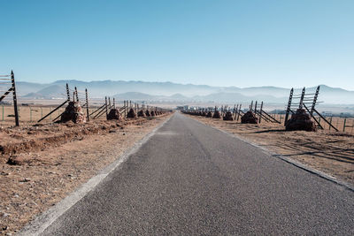 Empty road on field against clear sky