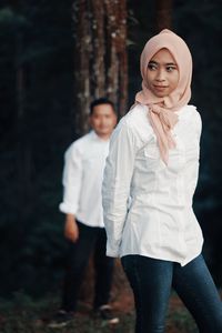 Woman in hijab walking with man at forest