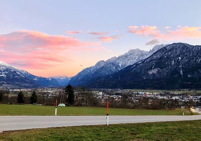 Scenic view of field and mountains against sky during sunset