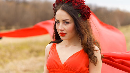 Woman in red dress looking away outdoors