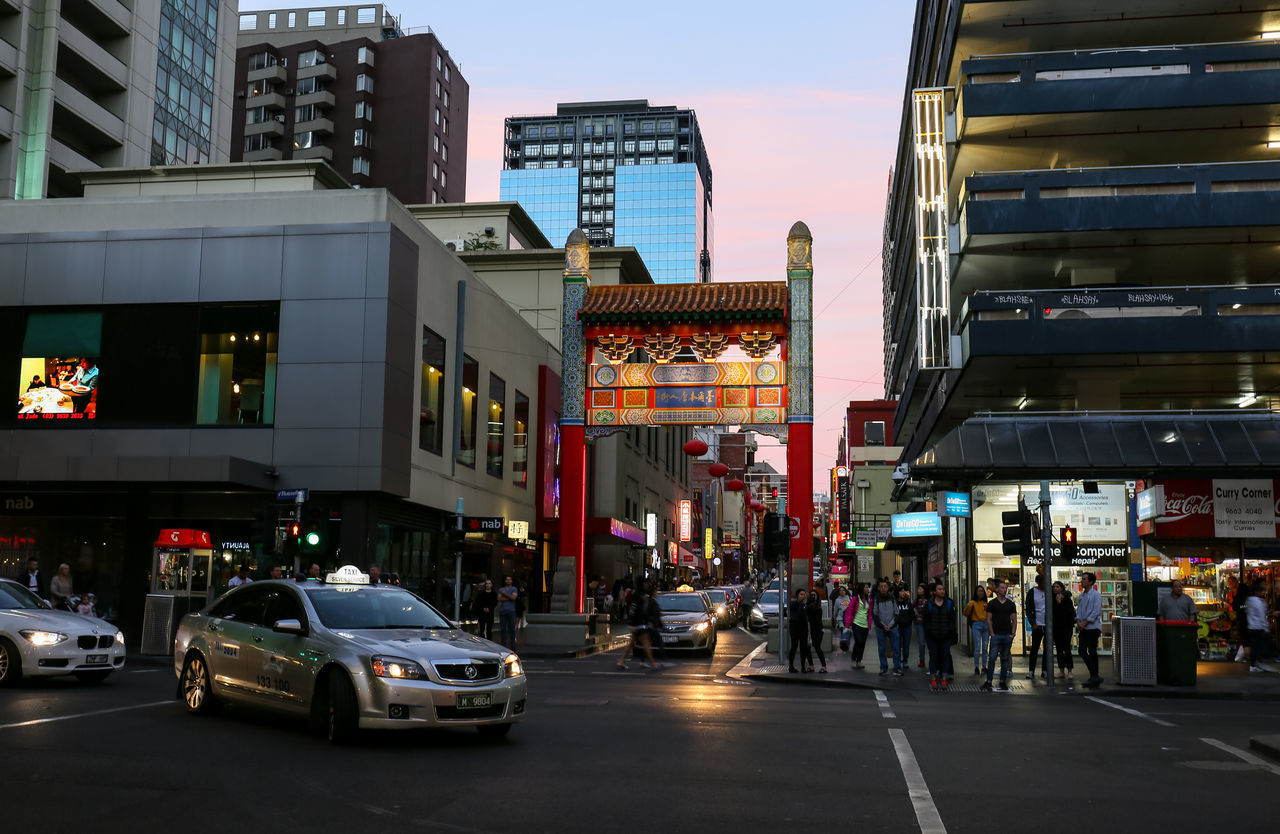 VEHICLES ON ROAD AMIDST BUILDINGS IN CITY