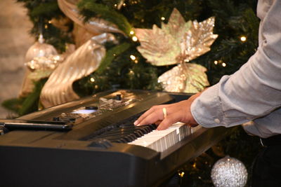 Cropped hand of man playing piano