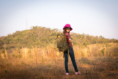 Full length of woman standing on field against sky