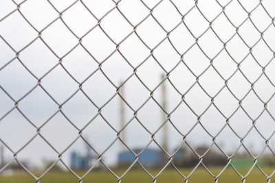 Close-up of chainlink fence against sky