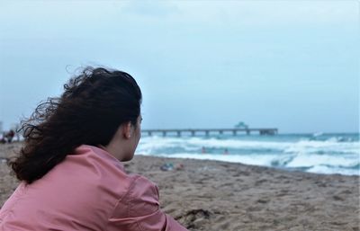 Portrait of woman on beach against sky