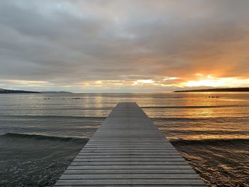 Pier over sea against sky during sunset