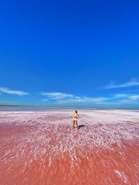 Man on beach against blue sky