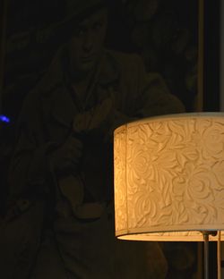 Close-up of illuminated lamp over black background