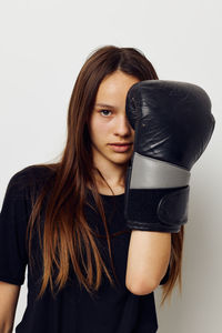 Portrait of young woman with blond hair against white background