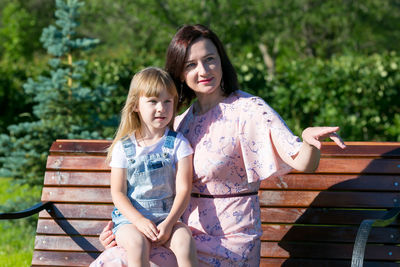 Portrait of a smiling young woman sitting on bench