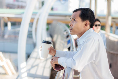 Side view of man looking at camera