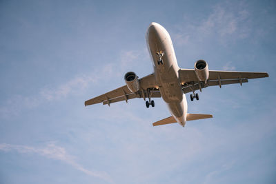 Low angle view of airplane flying against sky