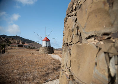 Traditional windmill on land against sky