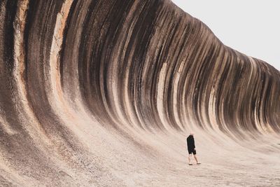 Rear view of man walking on desert