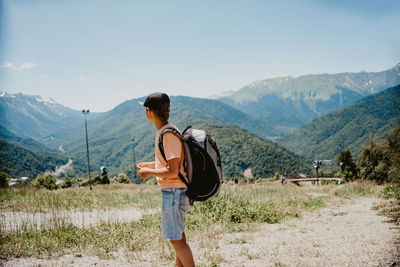 Side view of man standing against mountain