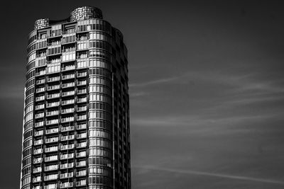 Low angle view of modern building against cloudy sky