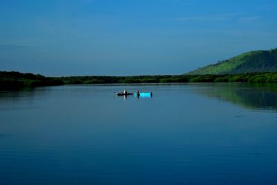 Scenic view of lake against clear blue sky