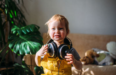 Portrait of cute smiling girl holding toy at home