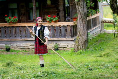 Woman holding umbrella standing outside house