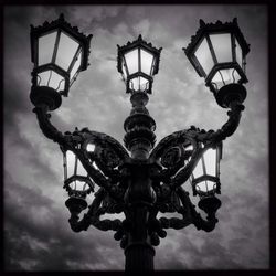 Low angle view of street light against cloudy sky