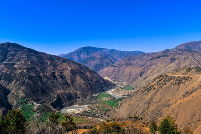 Scenic view of mountains against clear blue sky