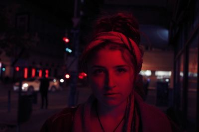 Portrait of young man in city at night