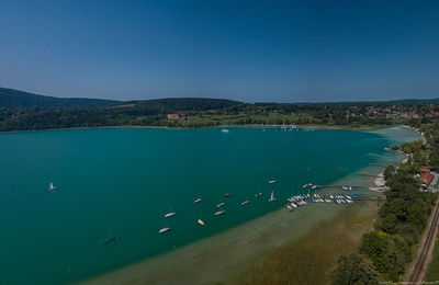 High angle view of boats in sea against clear blue sky