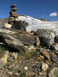 Rocks on mountain against sky and glacier