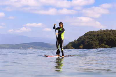 Female sup surfer on a wave