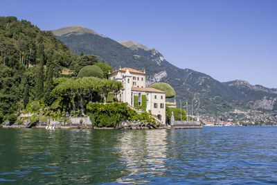 Scenic view of lake by buildings against clear sky