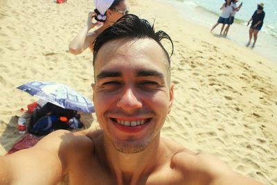 Close-up portrait of shirtless man at beach